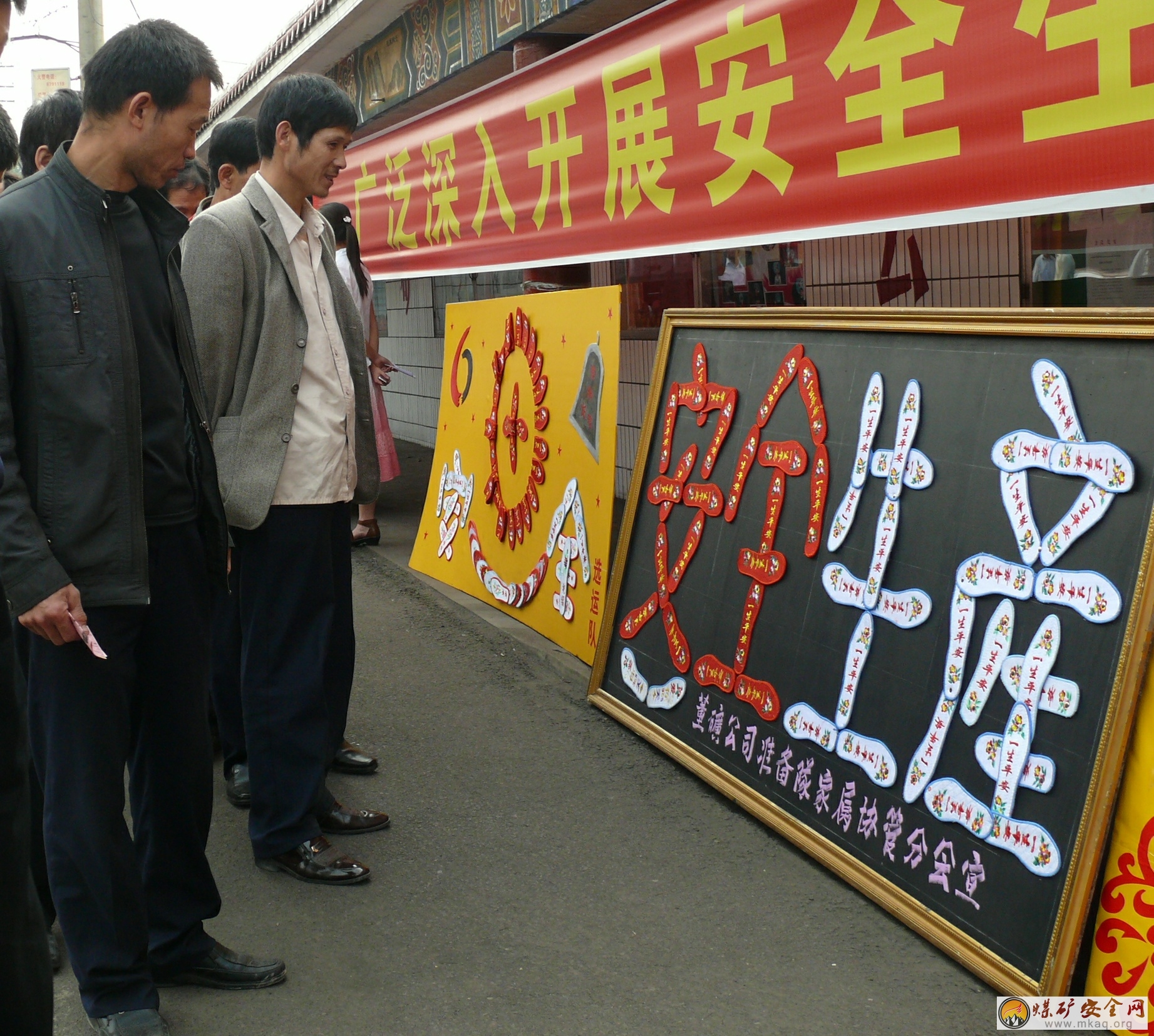 ?在安全生產(chǎn)月活動中，董礦分公司開展了安全牌板展活動，圖為干部職工觀看安全牌板時的情景